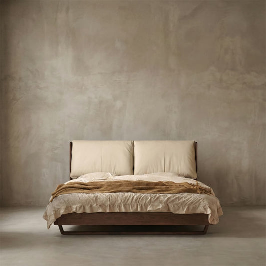 Modern bed with cream leather headboard and solid walnut frame in minimal beige room