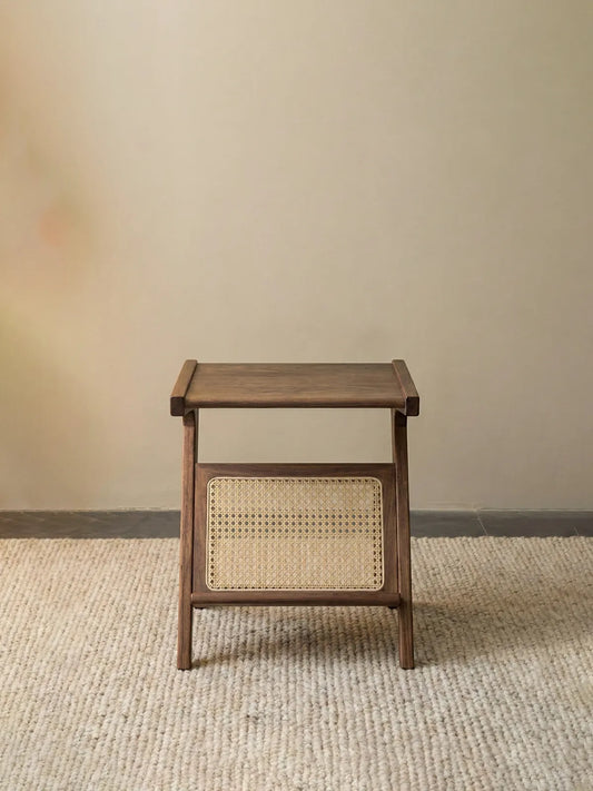 Front view of the Sylvan Z-table centered, clearly showing the texture of the hexagonal cane weaving and walnut legs.