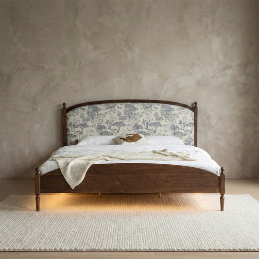 Elegant solid walnut bed frame featuring a fabric-upholstered headboard with a blue and white vintage landscape pattern and turned wooden legs.