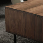 Close-up of 100% solid walnut wood furniture corner with dovetail joints and black metal leg