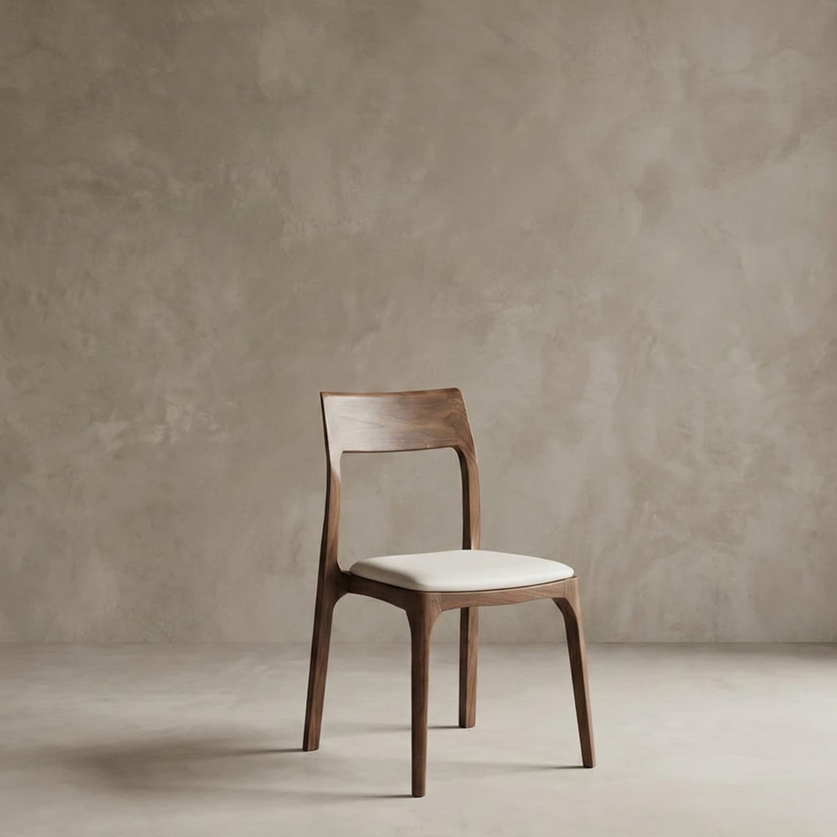 Minimalist solid North American black walnut dining chair with white upholstered seat against neutral textured wall