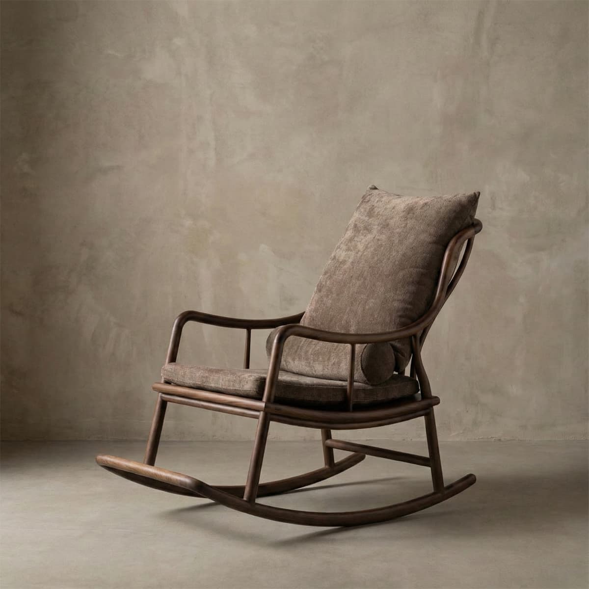 Elegant walnut rocking chair with plush brown cushions against textured beige wall