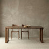 Solid North American black walnut dining table with two matching curved-back chairs on a beige rug