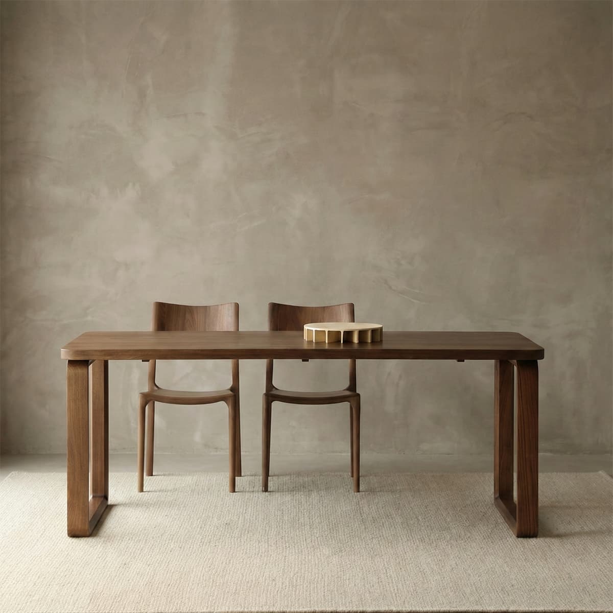 Solid North American black walnut dining table with two matching curved-back chairs on a beige rug
