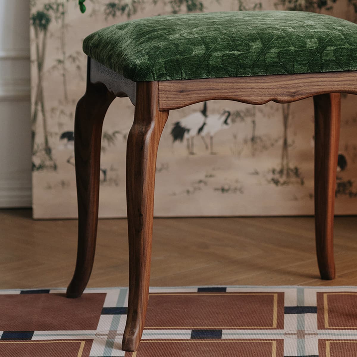 Solid North American Black Walnut stool with green velvet cushion on patterned floor
