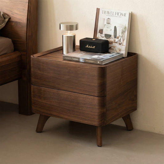 Solid North American black walnut nightstand with rounded drawers, modern lamp, speaker, and books