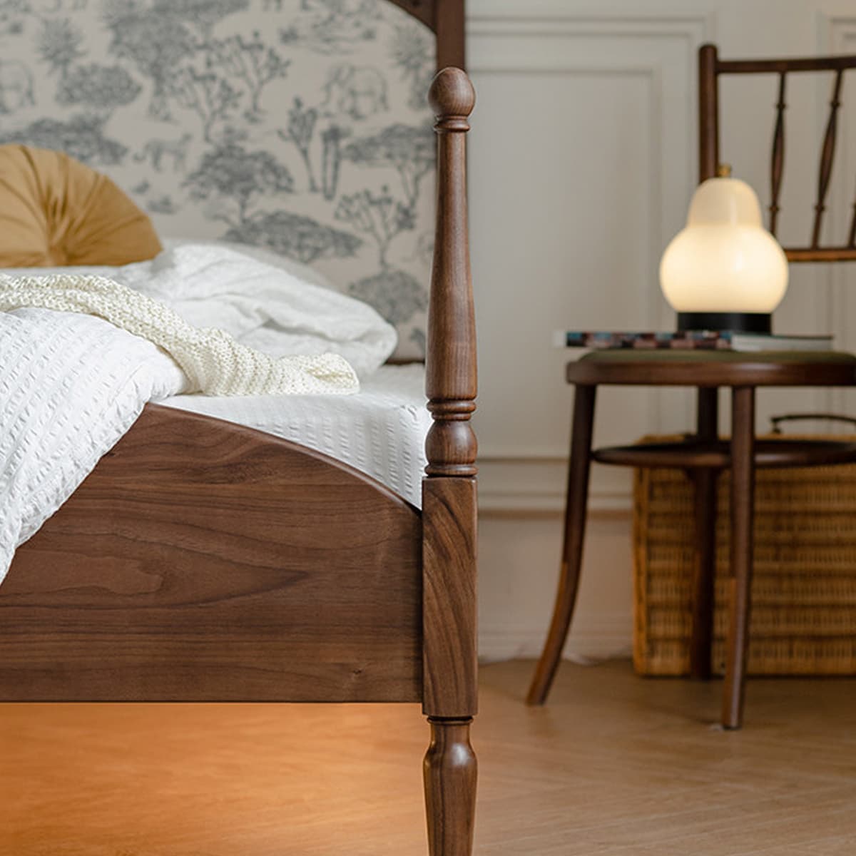 Solid black walnut bedpost with white bedding and beige pillow, wooden chair with lamp in cozy bedroom