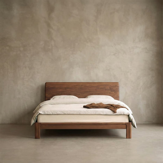 Solid black walnut bed with minimalist design in a neutral room, featuring white bedding and brown throw