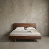 Minimalist bedroom featuring a solid North American black walnut bed with natural finish and neutral bedding
