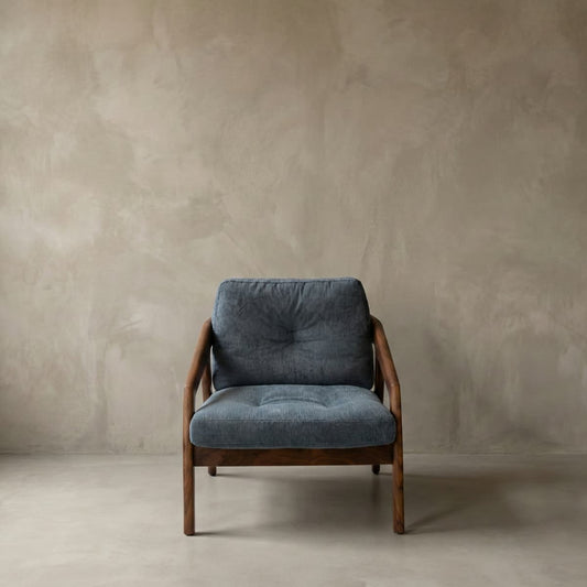 Modern lounge chair with solid North American Black Walnut frame and gray cushioned seat against textured beige wall