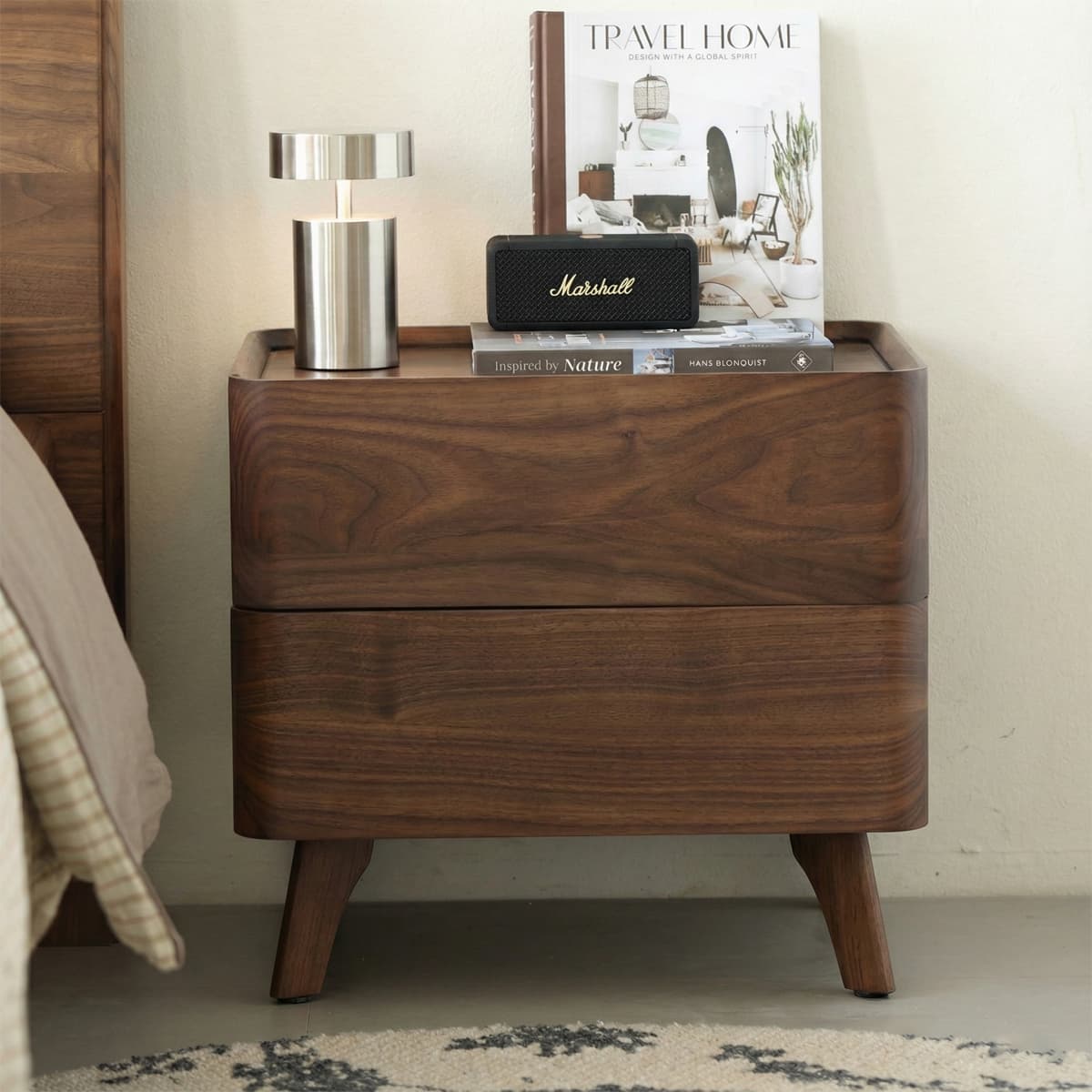 Solid North American black walnut nightstand with rounded edges, metal lamp, books, and Marshall speaker
