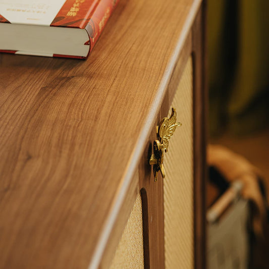 Close-up of solid North American Black Walnut furniture surface with golden butterfly latch and book edge