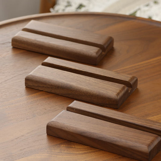 Three solid North American black walnut wooden stands on a walnut furniture surface with a natural oil finish.