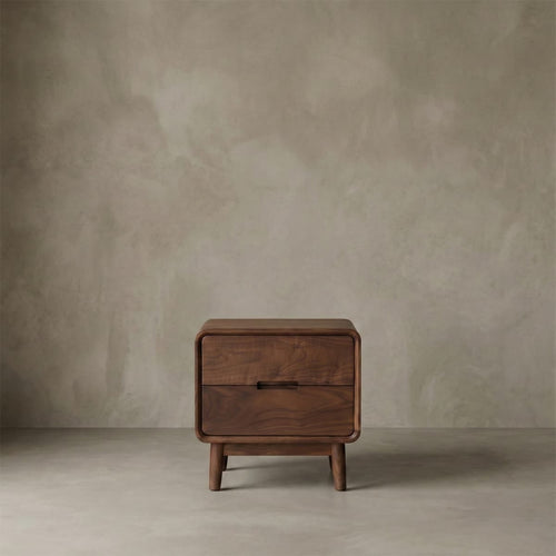 Modern solid North American black walnut nightstand with rounded edges and two drawers against a neutral textured wall