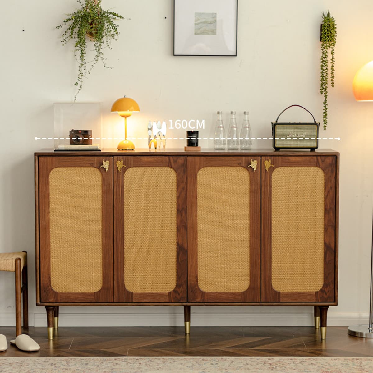 Solid black walnut sideboard with four woven rattan doors, gold butterfly handles, decorative lamps, glass bottles, and a speaker