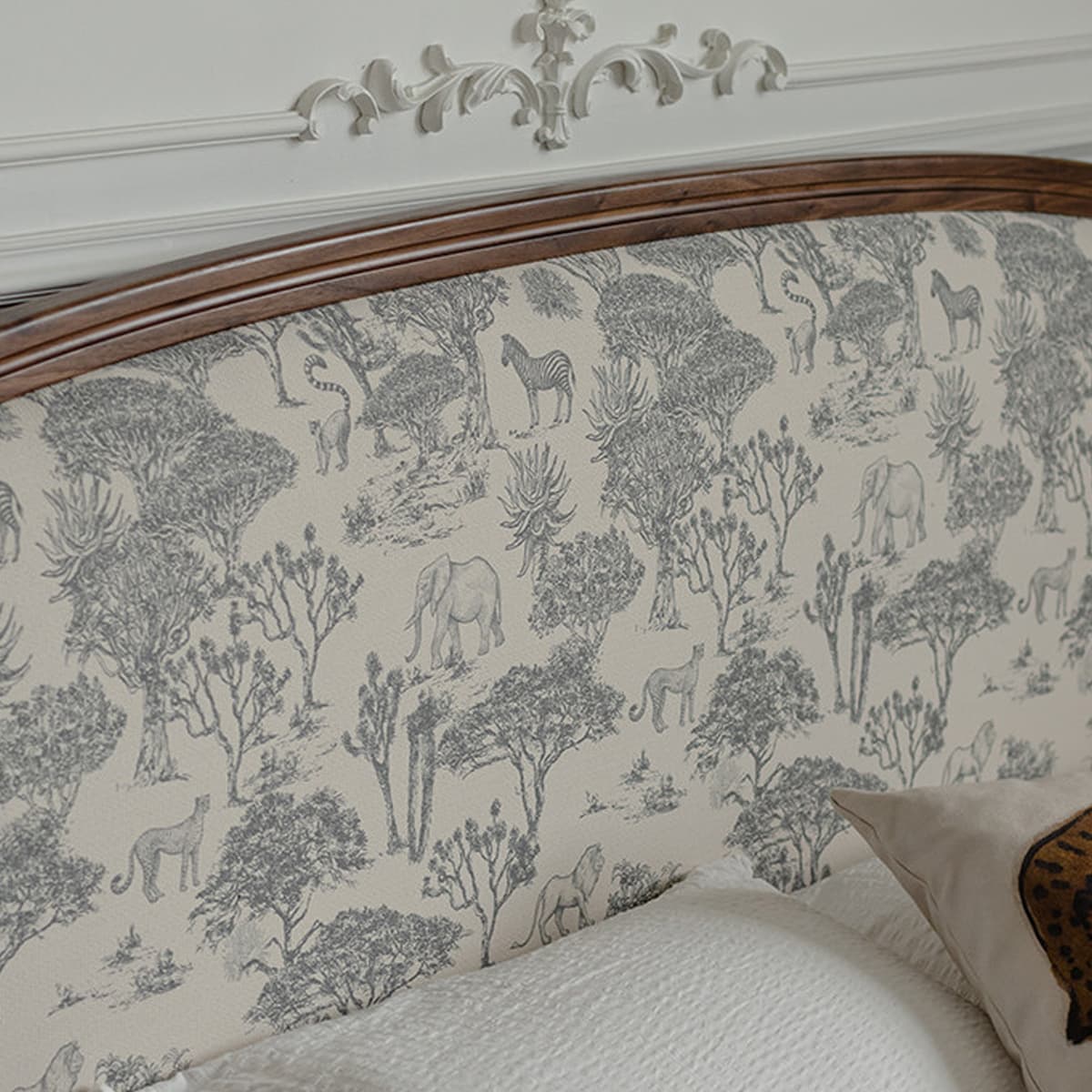 Solid wood bed headboard with detailed gray wildlife and tree patterns on fabric upholstery