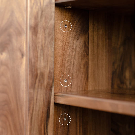 Close-up of solid black walnut wood bookshelf interior showing adjustable shelf holes with natural oil finish