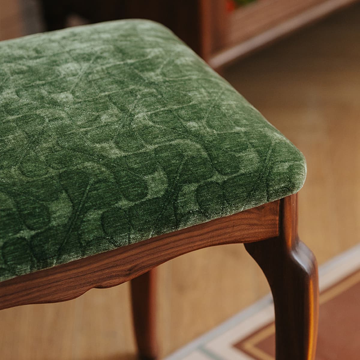 Close-up of heirloom-style solid black walnut chair with green velvet patterned upholstery