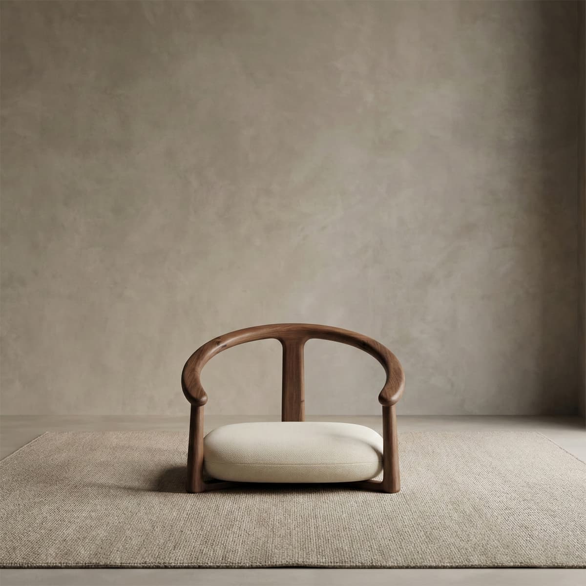 Modern low-profile chair with curved solid North American black walnut frame and cream cushion on textured rug