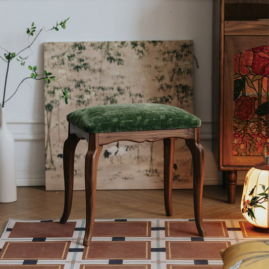 Solid North American black walnut stool with green velvet upholstery in a cozy interior setting
