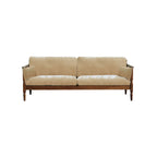 Apricot beige fabric sofa with wooden frame and two matching cushions on white background