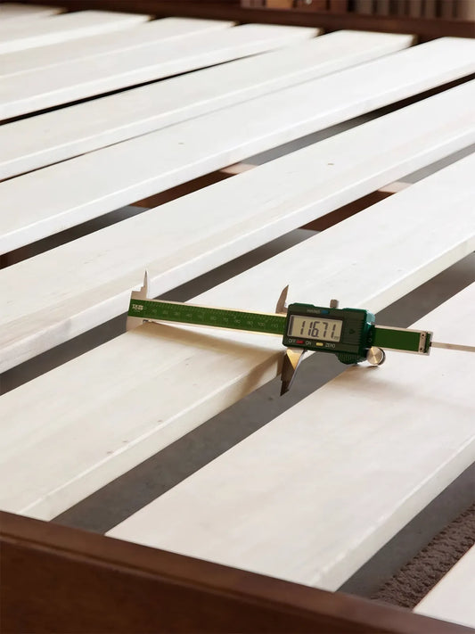 Measurement of bed slat spacing showing durable solid wood construction for mattress support.