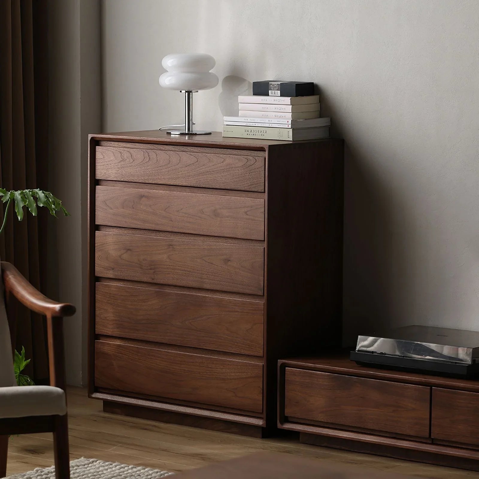 Solid North American Black Walnut five-drawer chest with modern white lamp and stacked books in minimalist bedroom corner