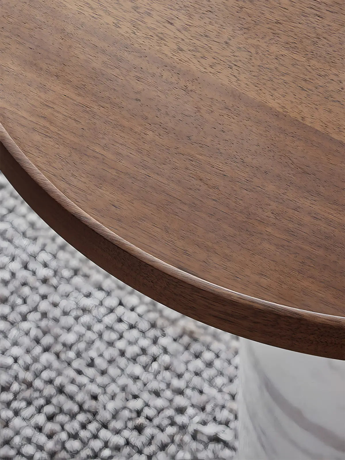 Close-up of natural walnut wood grain on round table top with handcrafted chamfered edge detail.