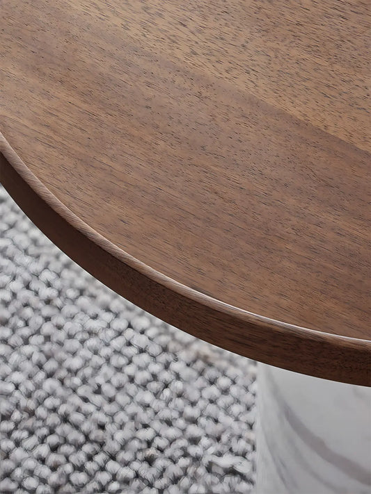 Close-up of natural walnut wood grain on round table top with handcrafted chamfered edge detail.