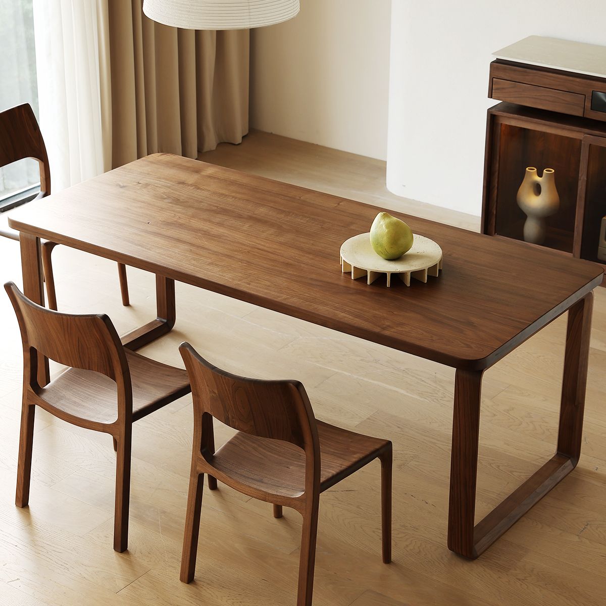 Minimalist dining room with solid wood table, two matching chairs, and modern decor