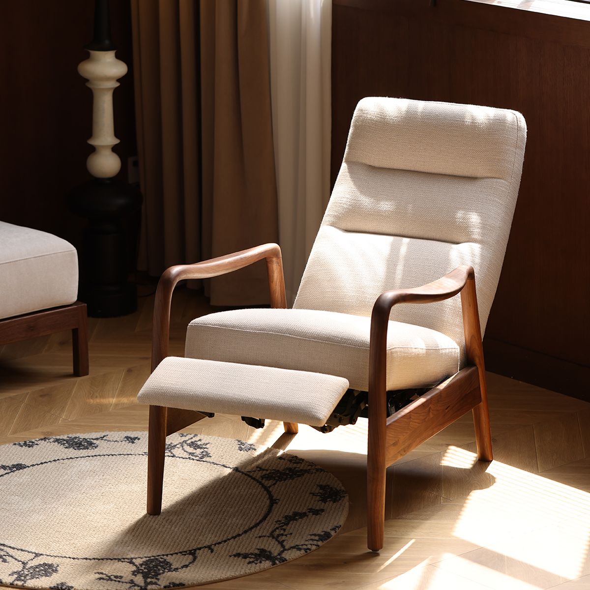 Beige cushioned recliner with wooden arms and footrest in sunlit modern living room