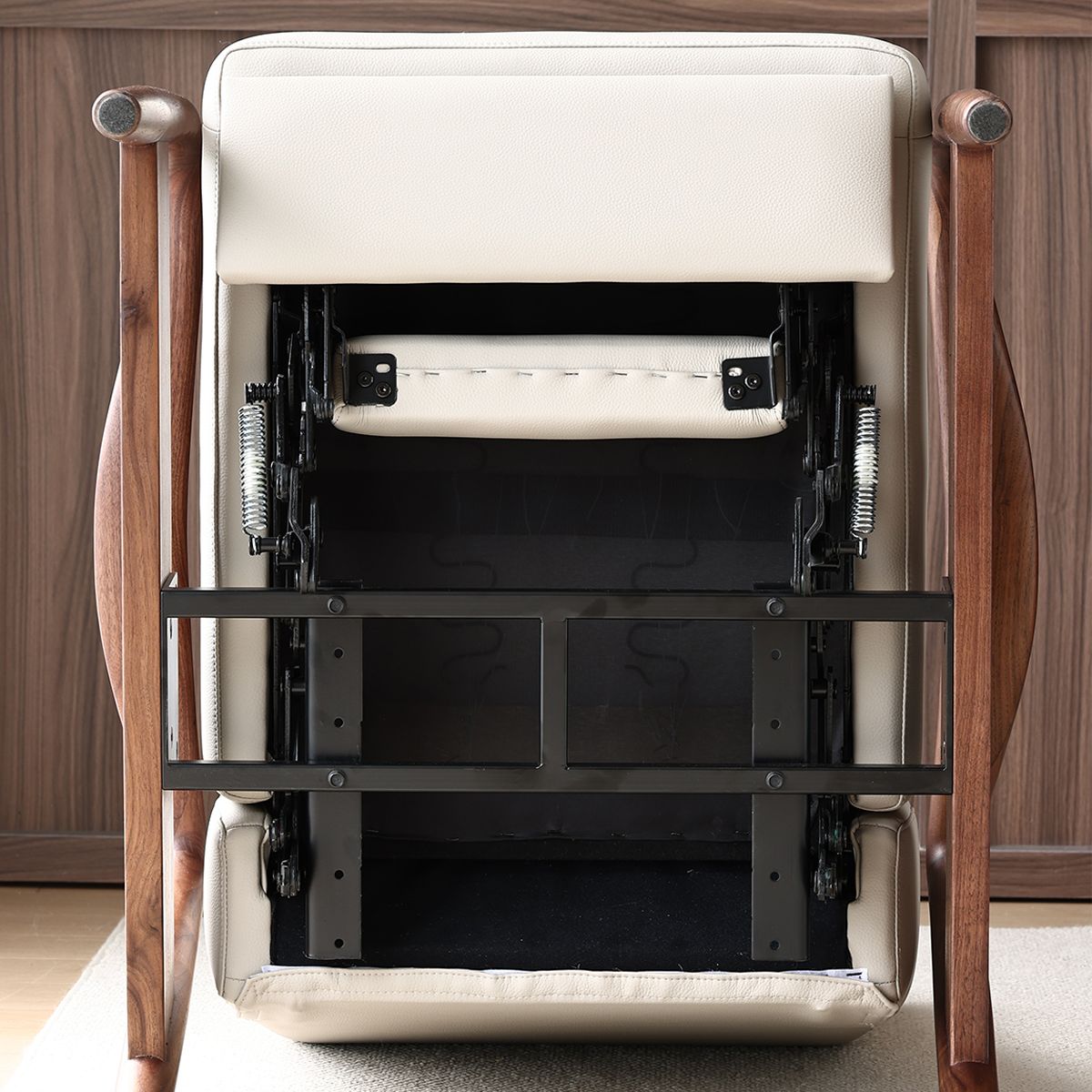 Underside of cream leather chair with solid North American black walnut frame showing metal support structure
