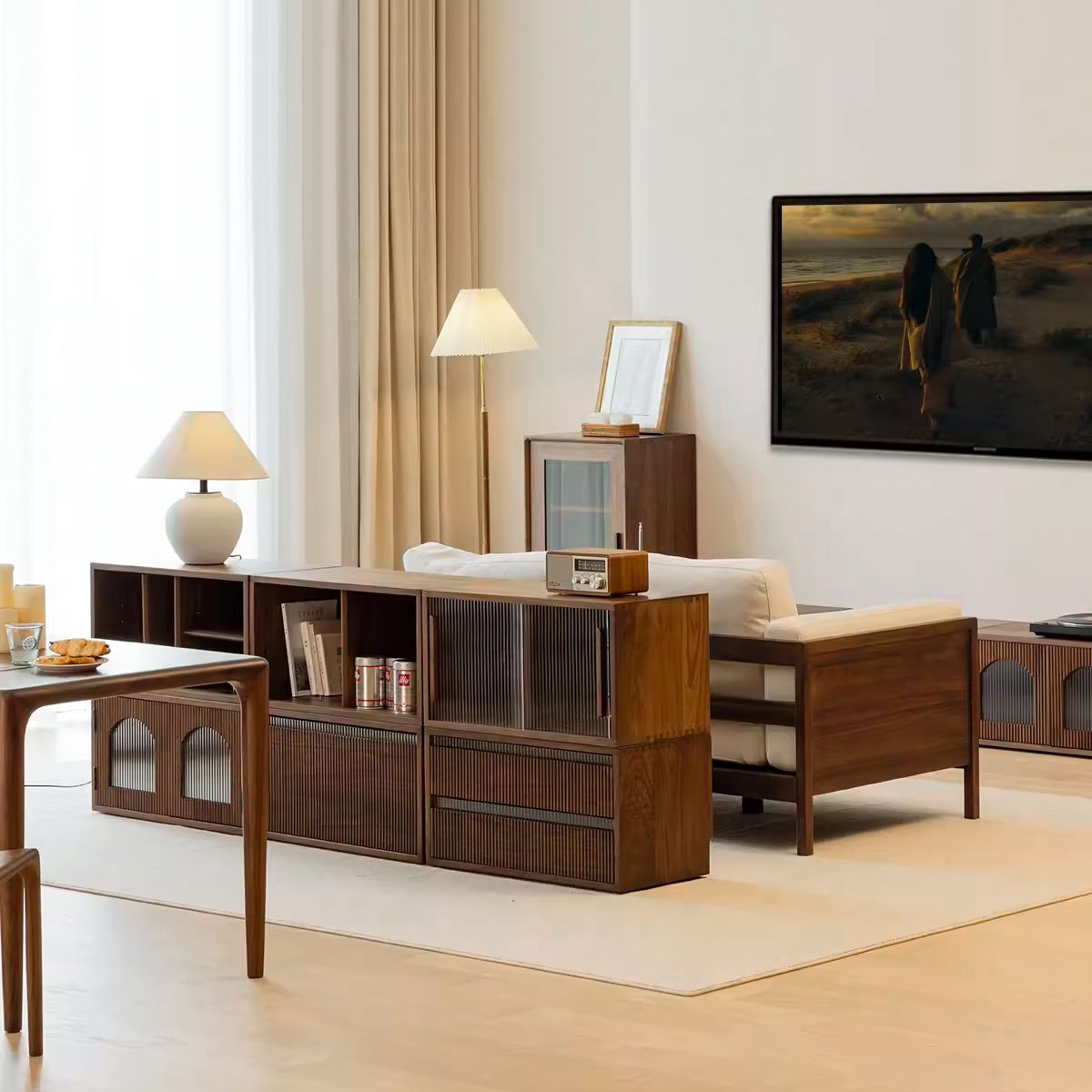 Modern living room with wooden furniture, white sofa, floor and table lamps, and wall-mounted TV