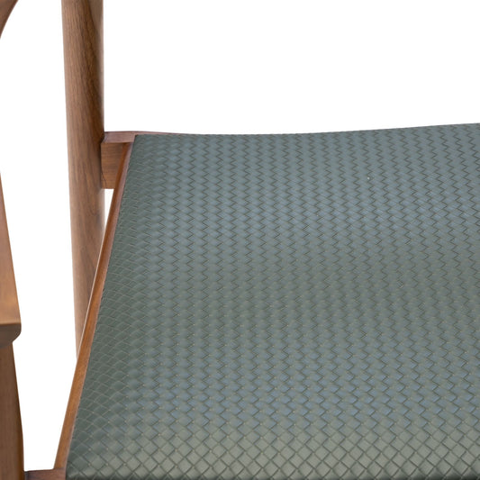 Close-up of woven green seat cushion on a wooden chair frame with a white background