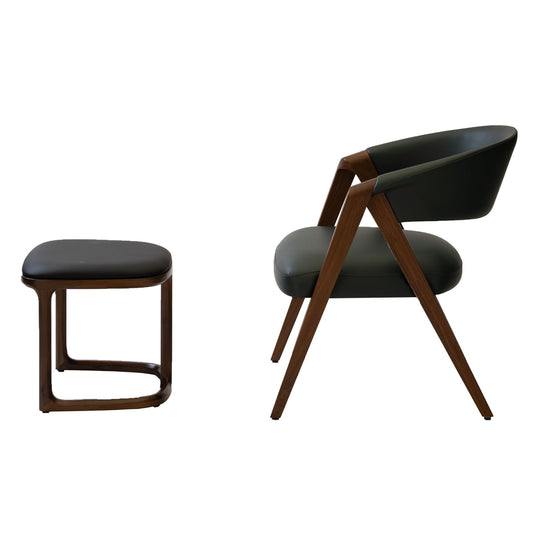 Modern dark green leather armchair with wooden legs and matching cushioned stool on white background