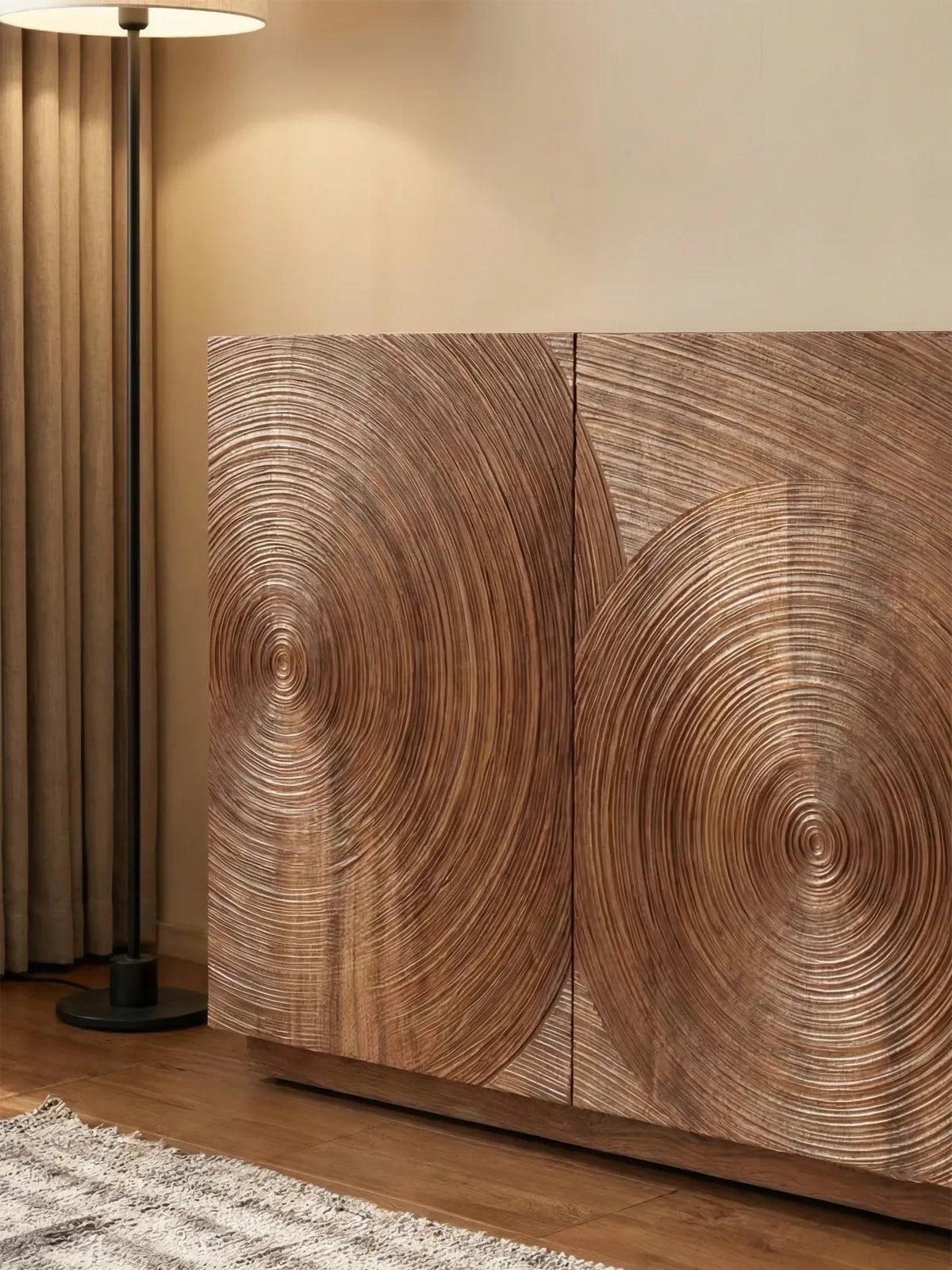 Close-up detail of the Curator sideboard, highlighting the intricate hand-carved concentric circle pattern and natural wood grain.