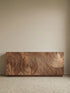 Angled view of the Curator sideboard with a door open, revealing spacious interior shelving and the thick solid wood door construction.