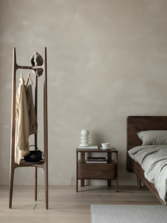 A cozy Dark Japandi style bedroom featuring the Walnutry nightstand styled with a ceramic lamp and linen bedding.