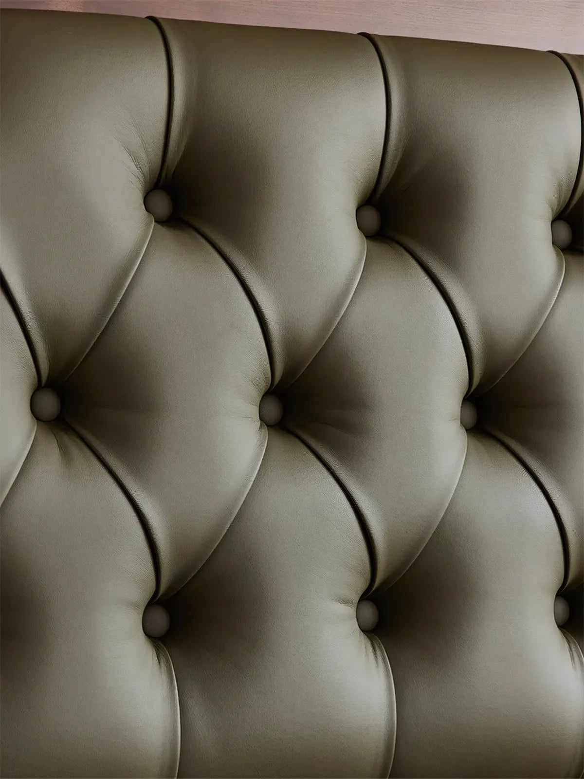Close-up detail of deep diamond tufting on emerald green top-grain leather headboard.