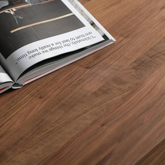 Close-up of FAS-grade North American Black Walnut tabletop with natural oil finish and an open magazine