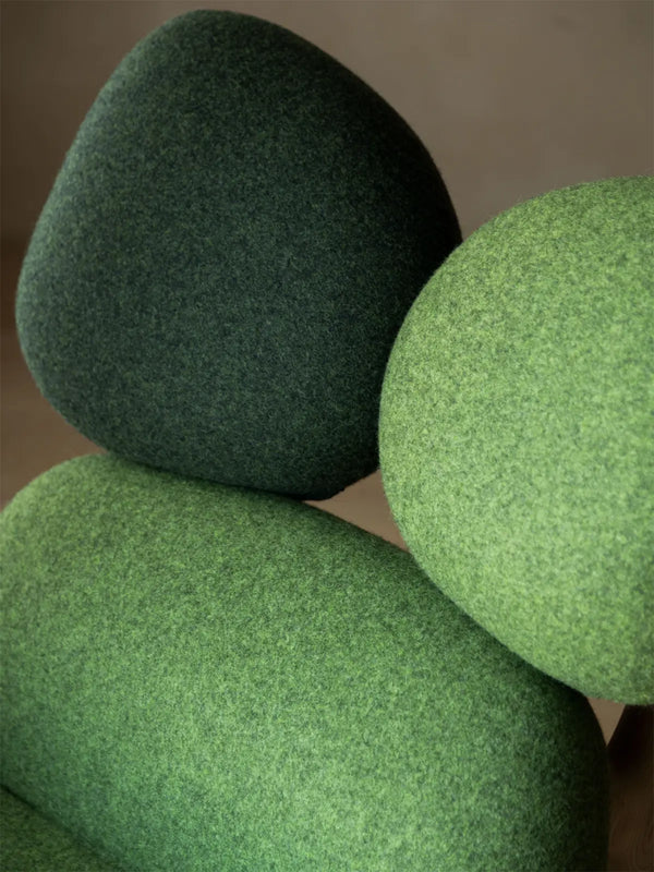 Macro detail of the premium green felted wool upholstery on the Cairn Rocker seat cushion.