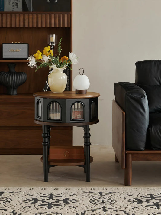 Sylvan fluted drum table with reeded glass doors styled with a black leather sofa.