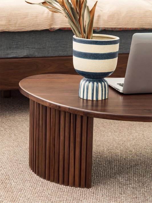 "Detail of the handcrafted fluted solid wood legs and rounded edge profile of the Kurumi table."