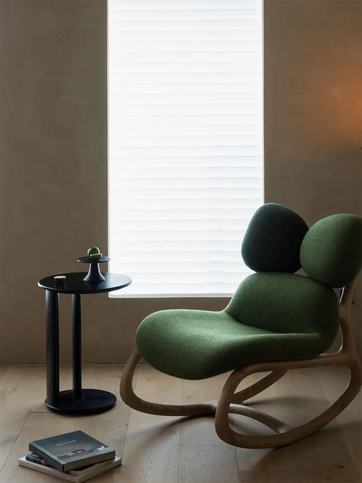 The Cairn Rocker in Moss Green wool, styled in a minimalist room with natural light, emphasizing biophilic design.