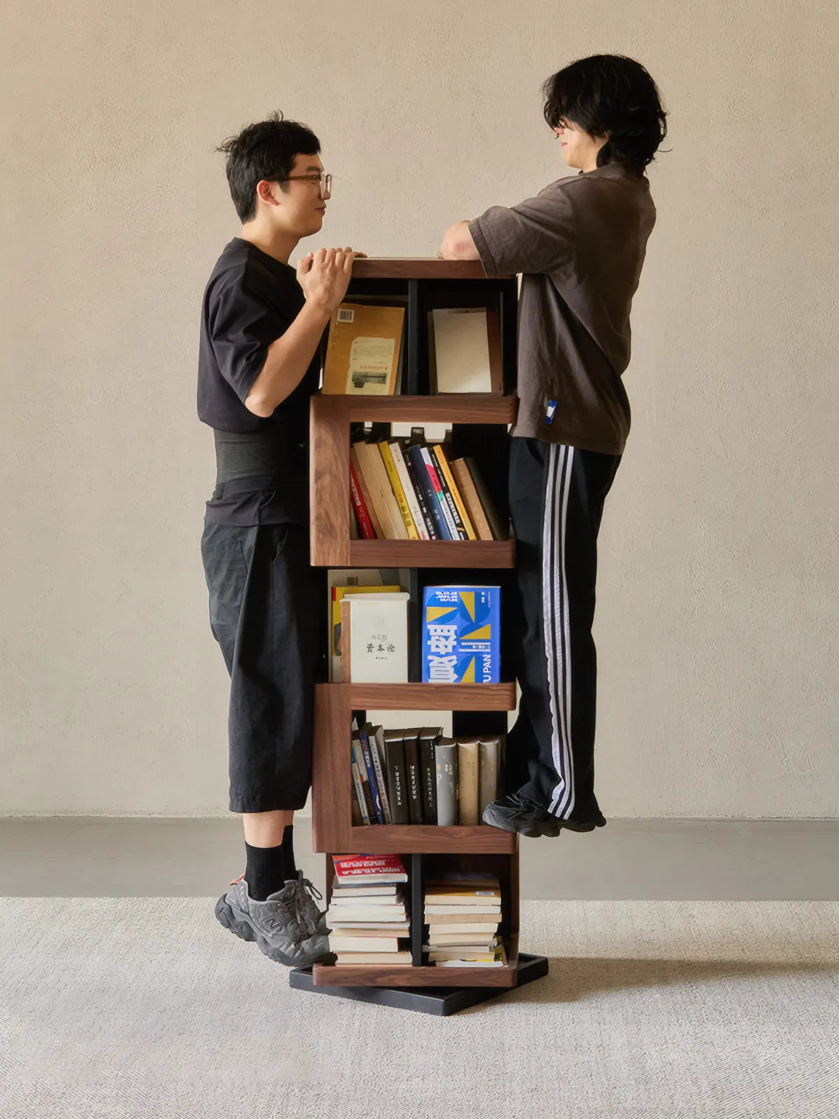 Strength demonstration showing two adults standing on the Walnutry solid wood bookshelf to prove stability and build quality.