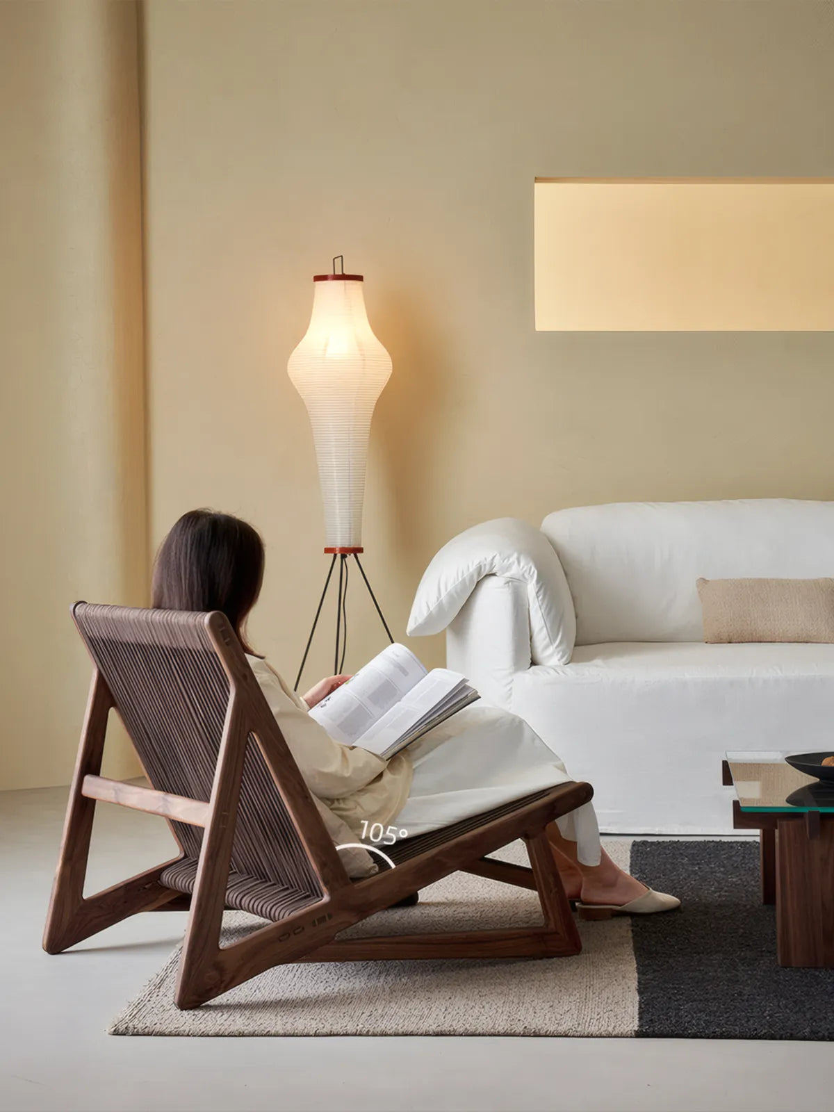 Side profile of organic modern accent chair highlighting the ergonomic 105-degree backrest angle in a warm living room setting.