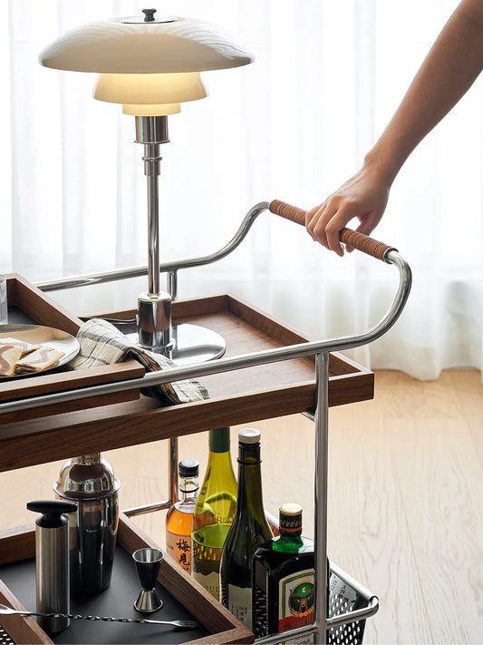 Detail shot of the hand-wrapped saddle leather handle on the chrome frame of the Walnutry serving cart.