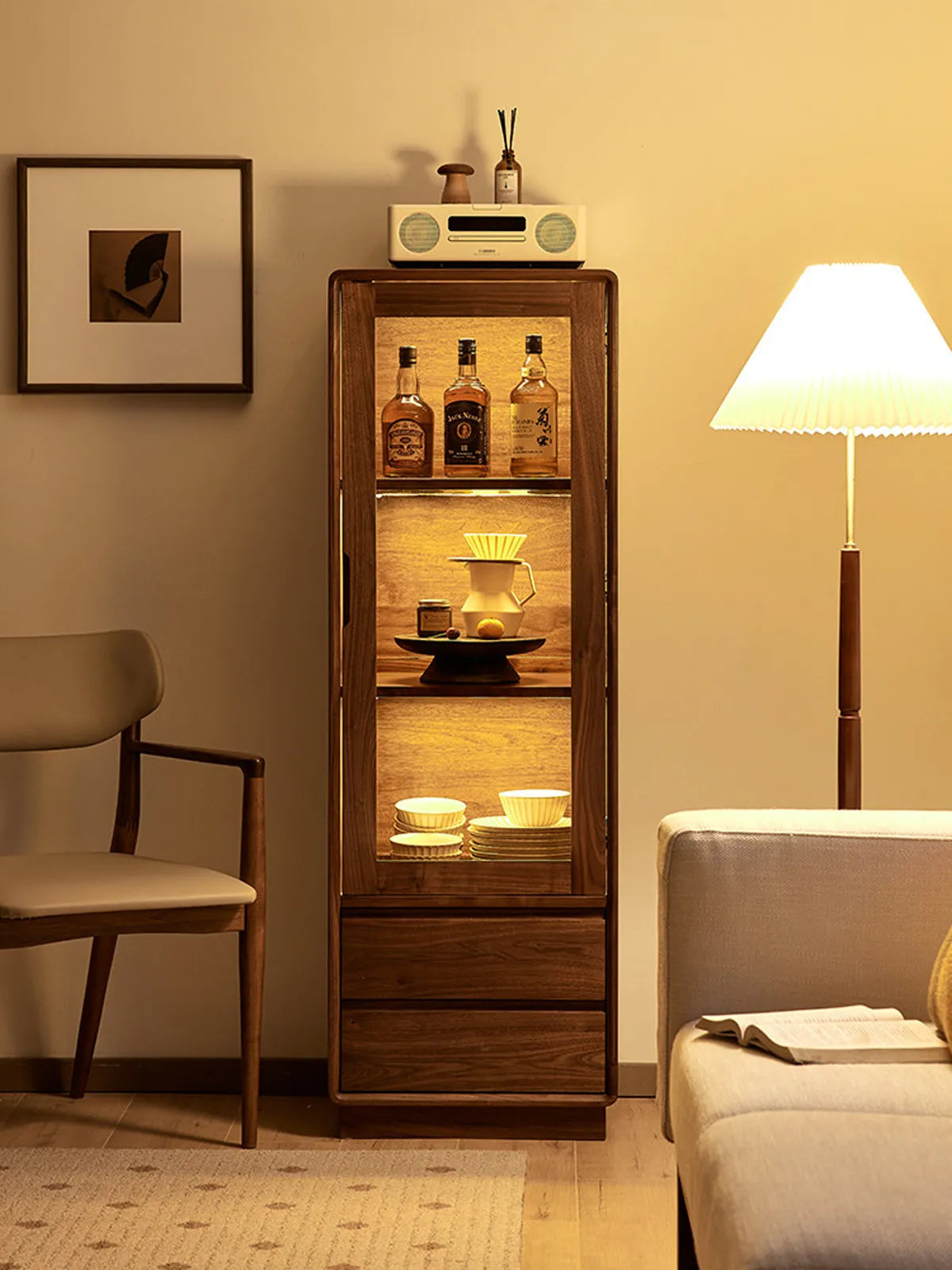 Interior view of the Kurumi cabinet illuminated with warm lighting, showcasing glass shelves and walnut finish.

