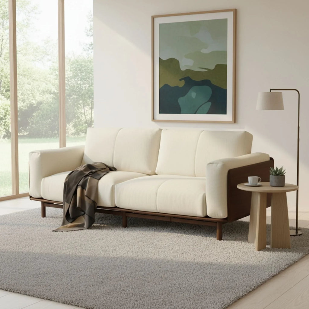 Modern cream sofa with walnut frame in bright living room with abstract wall art and side table