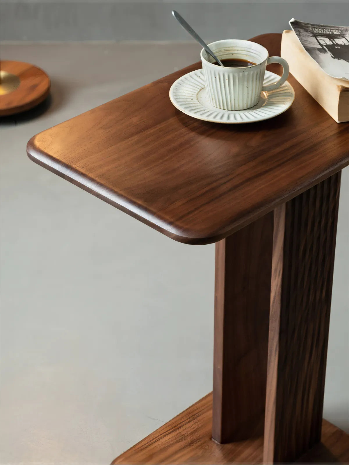 The Meridian C-Table crafted from solid North American Black Walnut, showing rich dark wood grain and sleek cantilever design against a neutral background.